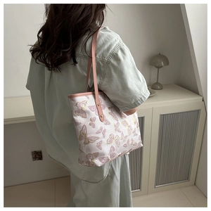 Close-up of pink embroidered butterfly pattern and faux leather strap on tote bag
