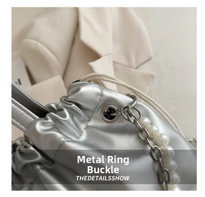 Close-up of silver drawstring bag hardware with metal buckle and pearl chain detail