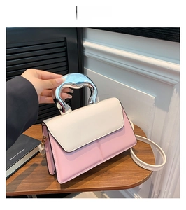 Détail du sac à main patchwork rose et blanc avec poignée métallique argentée