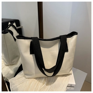Detail of white PU tote bag featuring geometric stitching and wide black shoulder strap