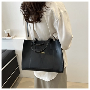 Detail view of large black PU leather tote bag with gold lettering and shoulder strap