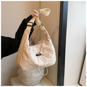 Detail of off-white wrinkled nylon crossbody bag with adjustable strap and drawstring buckle