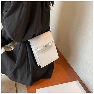 Detailed view of cream leather mini crossbody bag featuring silver turn-lock and texture