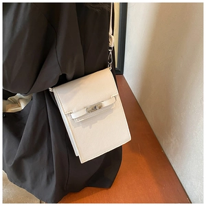 Detailed view of cream vertical mini crossbody bag with silver twist lock and crossgrain texture