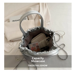 Top view of silver drawstring bucket bag showing interior space with phone and makeup