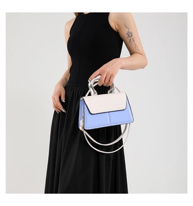 Détail du sac bandoulière bleu et blanc avec une poignée métallique argentée