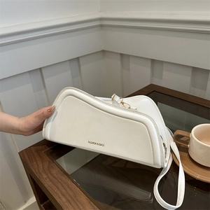 Chic white minimalist shoulder bag with gold lettering and asymmetrical geometric design
