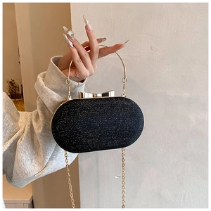 Detail of black sequined evening bag with golden ring handle and bow clasp hardware