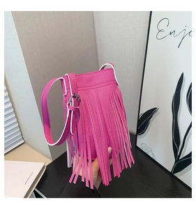 Detail of rose red tassel mini bucket bag featuring pebble leather and silver hardware