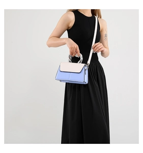 Détail du sac bandoulière bicolore bleu et crème avec poignée en métal argenté en U
