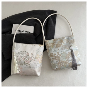Vue détaillée de sacs seaux en satin avec broderie chinoise traditionnelle et pompons