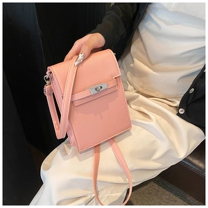 Detail of pink cross-pattern leather phone bag with silver twist lock and fine strap
