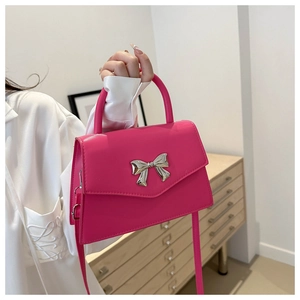Macro shot of stylish magenta handbag with a metallic silver bow buckle and PU leather texture
