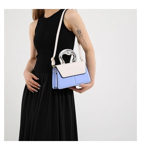 Détail du sac bandoulière bicolore bleu clair et blanc avec poignée métallique moderne