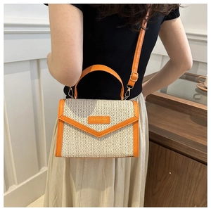 Détail du sac en paille beige avec garniture en cuir orange et plaque Fashion à l'intérieur