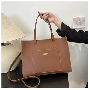 Close-up of brown PU leather tote bag with a front pocket and JINGPINPIJU brand logo