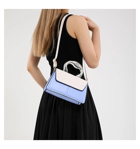 Vue latérale du sac bandoulière bicolore avec poignée métallique fluide et corps bleu
