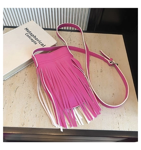 Macro view of rose pink fringe crossbody bag with litchi grain leather texture