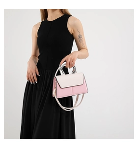 Detail of pink and white crossbody bag featuring a unique silver semi-circle metal handle