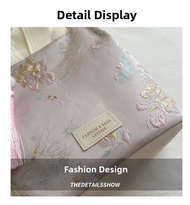 Detail of floral butterfly silk embroidery and leather label on pink bucket bag