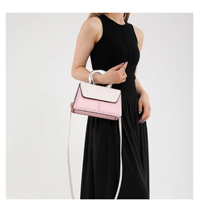 Détail du sac bandoulière rose et beige avec poignée en métal argenté et bandoulière