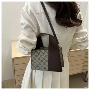Detail der Vintage-Tasche mit geometrischem Print, Ledergriff und verstellbarem Riemen