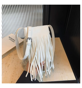 Detailed view of white fringed crossbody phone bag with pebble leather and silver hardware