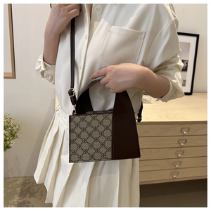 Detailansicht der Vintage-Monogramm-Schultertasche mit Ledergriff und verstellbarem Gurt
