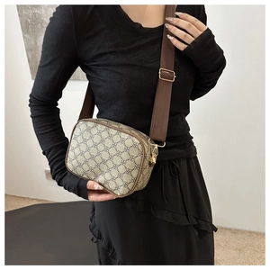 Détail d'un sac bandoulière vintage à monogramme avec large sangle en tissu réglable