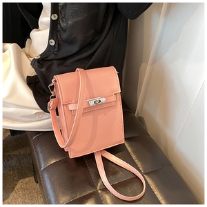 Detail of pink mini crossbody bag featuring pebble texture and silver metal twist lock