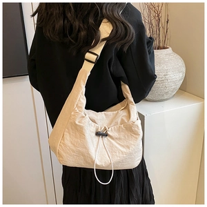 Close-up of lightweight nylon crescent bag with adjustable wide strap in cream white