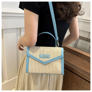 Detail shot of straw and light blue leather crossbody bag with adjustable strap