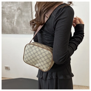 Gros plan d'un sac bandoulière rétro avec motif floral marron porté par un mannequin