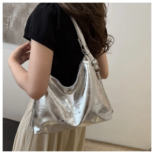 Detail of silver metallic tote bag with embossed lettering and metal chain strap