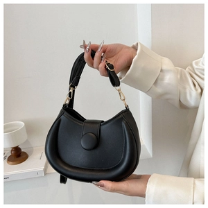 Detailed shot of black half-moon saddle bag with golden metal buckle and leather texture