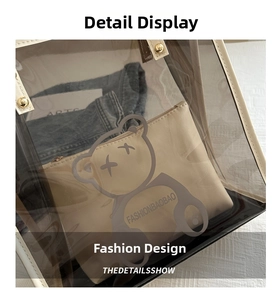 Detail of transparent PVC tote bag with bear print, leather straps, and golden rivets