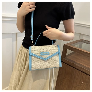Detail of herringbone straw handbag with light blue leather trim and FASHION logo
