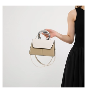 Détail du mini sac à rabat bicolore avec poignée semi-circulaire en métal liquide