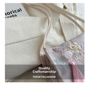 Close-up of elegant silk embroidery peony flowers and tassel detail on tote bag