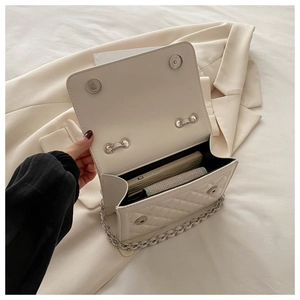 Detail of quilted leather crossbody bag showing magnetic closure and interior storage space