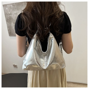 Gros plan sur le sac hobo argenté métallisé avec lettres embossées et bandoulière