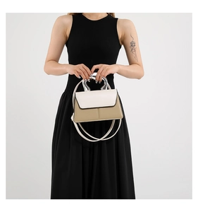 Détail d'un sac à main chic contrasté avec poignée métallique argentée et bandoulière