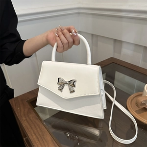 Elegant cream white leather handbag with silver metal bow and detachable shoulder strap