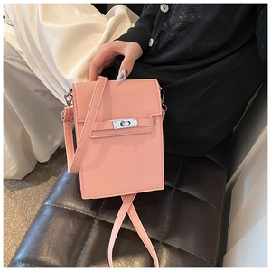 Detail of pink mini crossbody bag featuring a silver metal turn-lock and leather texture