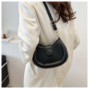 Minimalist black crescent crossbody bag with adjustable gold buckle shown on model