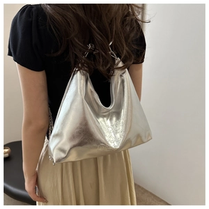 Detail of silver metallic hobo bag with embossed lettering and metal chain strap