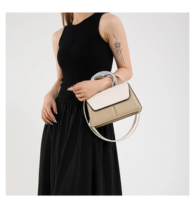 Détail de la poignée demi-cercle en métal sur le sac à main contrasté beige et kaki