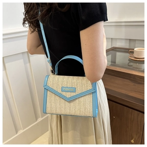 Détail du sac bandoulière en paille tendance avec finitions en cuir bleu et étiquette