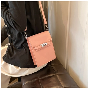 Detail of pink crossbody phone bag showing silver twist lock and lychee texture