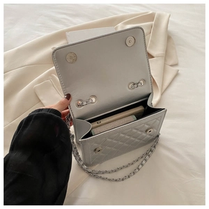 Detail view of silver quilted shoulder bag showing interior space for a smartphone